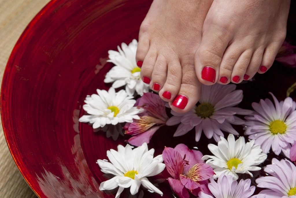 Pies en un bol con agua y flores